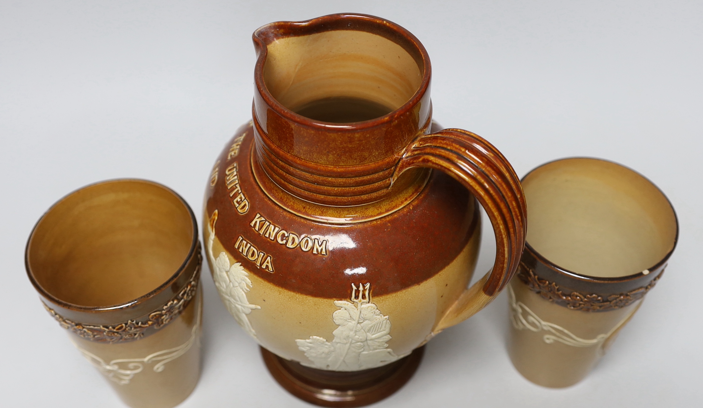 A Doulton stoneware jug and two tumblers, tallest 22cm